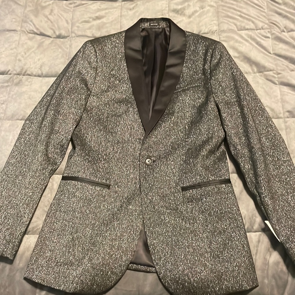 This slim fit blazer is a size 36 regular in the color “charcoal sparkle”.